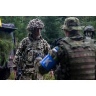 Des examinateurs estoniens se coordonnent avec un soldat britannique à Sonda, en Estonie.