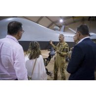 Le lieutenant-colonel Yann Kerneis du détachement drone 1/33 Belfort présente un drone de combat MQ-9 Reaper aux membres de la commission de la Défense nationale et des forces armées de l'Assemblée nationale, lors de leur visite à Niamey.