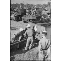 Des légionnaires de l'escadron antichars du 1er REC (régiment étranger de cavalerie) attèlent un canon de 57 mm M1 à un scout-car M3A1, sous les yeux du chef de corps, à l'issue de la prise d'armes près de la forêt de la Mamora.