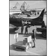 Des hommes accrochent un Douglas SBD Dauntless par l'empennage à un camion sur un quai du port de Casablanca.