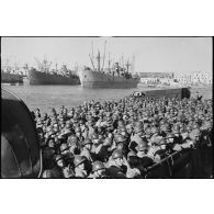 A bord d'un chaland qui vient d'accoster dans un port italien, les hommes attendent l'ordre de débarquement.