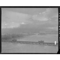 Passage de convois de scouts-cars et amphibies sur un pont de radeaux pneumatiques.
