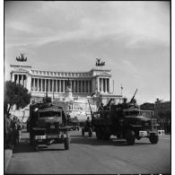 Défilé de camions GMC d'une unité des forces terrestres antiaériennes sur la piazza Venezia.