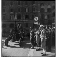 Canon antiaérien Bofors de 40 mm tracté par un camion GMC défilant dans une rue de Rome. du 40e groupe autonome colonial des forces terrestres antiaériennes.