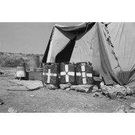 Devant une tente, des jerrycans de 20 litres réservés au transport et au conditionnement de l'eau potable.