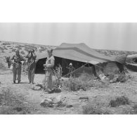 Après un repas sous la tente des bédouins, deux aviateurs échangent avec les bergers avant de quitter la tente.