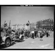 Cérémonie militaire dans Marseille libérée : défilé de membres des Forces françaises de l'intérieur (FFI) sur le quai des Belges du Vieux-Port.