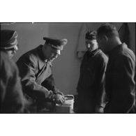Lors de sa tournée d'inspection auprès du schwere Panzer Abteilung 508, le général Kurt Student goûte à la nourriture dans les cuisines.