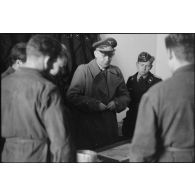 En pleine inspection du schwere Panzer Abteilung 508, le général Kurt Student se penche sur une carte de l'Italie.