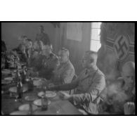 Le colonel (Oberstleutnant) Götsche déjeune en présence d'un général allemand et en compagnie d'officiers de la police allemande.