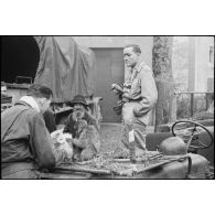 A Saulxures-sur-Moselotte tout juste libéré, un singe mascotte du 3e RTA et un chien sur une jeep du SCA sont l'attraction de quelques soldats et villageois et du photographe du SCA Roland Lennad.