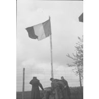Enfin, après cinquante-six mois, le drapeau français flotte sur le Stalag IV D, à Mühlberg (24 Avril 1945). [légende publiée en 1949]