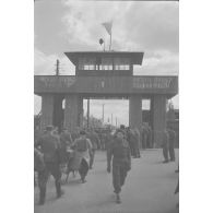 Un convoi de prisonniers polonais libérés quitte le Stalag IV B. Sur le mirador flotte le drapeau soviétique. [légende publiée en 1949]