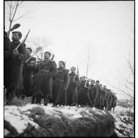 Après avoir travaillé à la réfection d'une route, des pionniers d'une unité de la 55e DI (division d'infanterie) sont rassemblés en ordre serré.