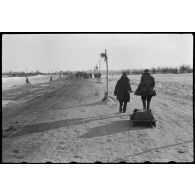 Sur une route enneigée, des civils quittent le secteur de Wjasma.