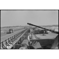 Durant l'opération Büffelbewegung, un convoi de camions traverse un pont sous la protection d'un canon de 2 cm FlaK 30, à droite l'ancien pont.