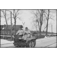 Devant l'isba qui contrôle l'accès à une voie ferrée, la sortie d'une moto chenillée NSU Kettenkrad, à son bord trois Jäger dont un officier.