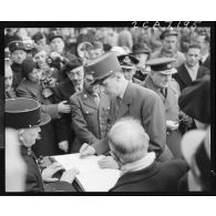 Le général de Gaulle signe le livre d'or de l'Arc de Triomphe lors de la cérémonie du 11 Novembre 1944 à Paris.
