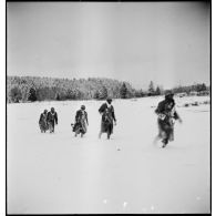 Tirailleurs sénégalais de la 9e DIC (division d'infanterie coloniale) progressant dans la forêt des Vosges enneigée, armés de pistolets-mitrailleurs Thompson M1A1.