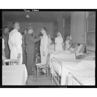 Le général de Lattre de Tassigny décore des blessés dans un hôpital du front.