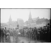 Place Kléber à Strasbourg, lors d'une cérémonie célébrant la libération de la capitale de l'Alsace par la 2e DB (division blindée), un détachement de musique militaire du 12e Cuir défile devant la foule venue nombreuse acclamer les libérateurs.