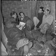Conversation entre journalistes et reporters militaires au sein d'un abri à Diên Biên Phu.