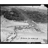 Vue aérienne des cérémonies du 14 juillet 1946 à Paris. Remontant les Champs-Elysées, des chars Sherman traversent la place de la Concorde.