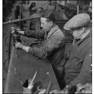 A l'atelier d'Issy-les-Moulineaux deux ouvriers perforent une plaque de blindage d'un char B 1 bis.
