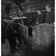 A l'atelier d'Issy-les-Moulineaux des ouvriers placent des plaques de blindage sur une caisse de char B1 bis.
