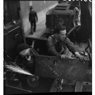 A l'atelier d'Issy-les-Moulineaux deux ouvriers meulent une plaque de blindage de char B1 bis.