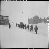 Au col du Lautaret en février 1940 des chasseurs alpins marchent en colonne derrière un chasse-neige.