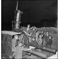 Des marins, appartenant à la 4e batterie mobile de défense antiaérienne de la Marine, chargent un canon antiaérien de 90 mm CA.