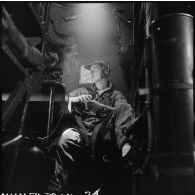 L'enseigne de vaisseau Tourel à bord d'un avion bombardier Privateer de la flottille 28F, fumant une cigarette.