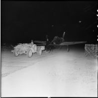 Remorquage de nuit d'un avion de chasse Beacat F8F par un véhicule Dodge sur le terrain d'aviation de Diên Biên Phu.