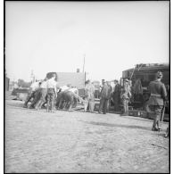 Plan général de soldats qui chargent du matériel sur un wagon ouvert.