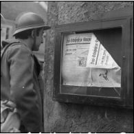 Dans une rue de Lauterbach, le portrait d'un soldat qui lit un journal de la Waffen-SS 