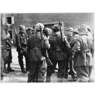 Des soldats de la 3e armée originaires d'Afrique du nord entourent un micro dans un village de Moselle.