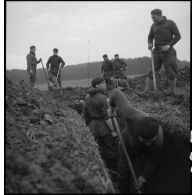 Des soldats de la 4e armée creusent des tranchées ou placent des bouchons de mines près d'un axe routier.