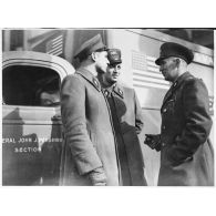 Photographie de groupe de trois volontaires américains de la 1re SSVA (general John J. Pershing) avec en arrière-plan une ambulance.