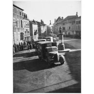 Ambulances de la 1re section sanitaire de volontaires américains (SSVA), qui porte le nom de general John J. Pershing, arrivent sur une place de Vic-sur-Seille.