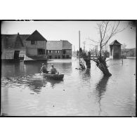Des soldats de la 4e armée se déplacent en barque au milieu d'un village lorrain inondé. (Puttelange-aux-Lacs).