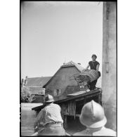 Des soldats de la 4e armée déménagent des affaires dans une barque lors de l'inondation d'un village. (Puttelange-aux-Lacs).