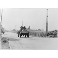 Plan général de face d'une automitrailleuse Guy Mk I du 12e lanciers britannique qui roule sur une route près de Thisnes le 10 mai 1940 à 14 heures.