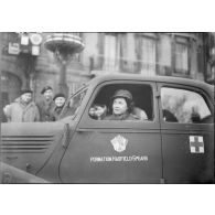 Une infirmière britannique de la Formation Hadfield Spears se tient au volant d'une Renault Primaquatre.