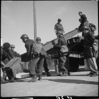 Des soldats de la 6e armée mettent en place des rampes d'accès à l'arrière d'un camion porte-chars.