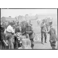 Des prisonniers allemands se servent à manger dans un camp de prisonniers.