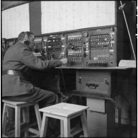 Portrait d'un opérateur du 28e RTrs (28e compagnie de radio transmissions) utilisant un appareil de transmissionss dans un central téléphonique.