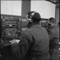 Des soldats utilisent des appareils de transmissionss dans un central téléphonique.