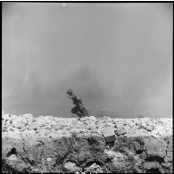 Soldat jaillissant dans la fumée des bombardements lors des combats de Diên Biên Phu.