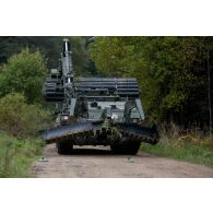 Un véhicule blindé Trojan des Royal Engineers britanniques progresse sur un chemin forestier miné à Tapa, en Estonie.